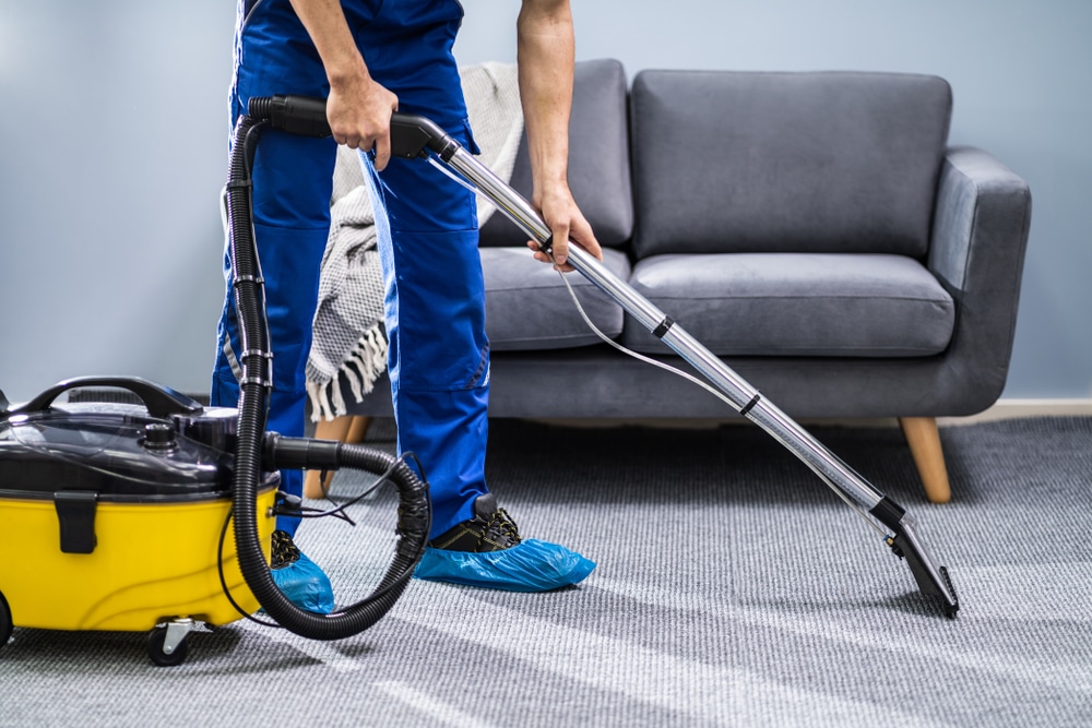 Photo Of Janitor Cleaning Carpet With Vacuum Cleaner