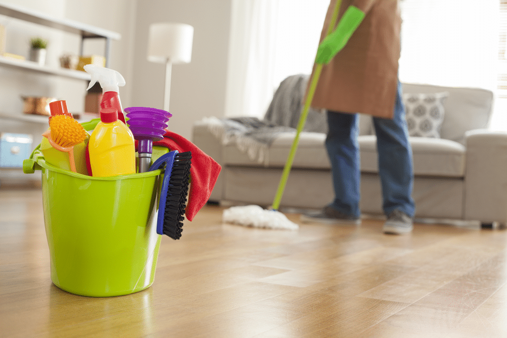 Man holding mop and plastic bucket