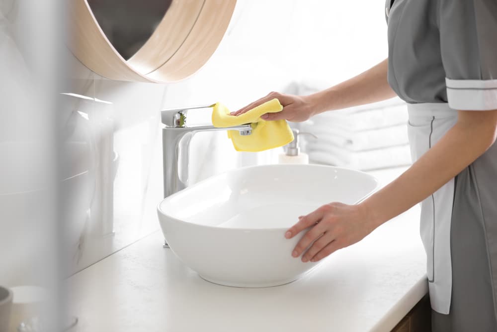 the women cleaning the bathroom with cleaner